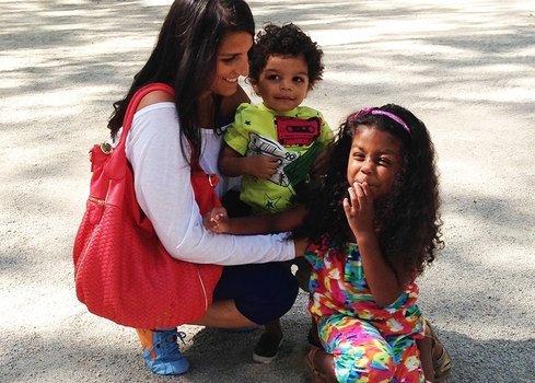 happy dark skin woman with two kids outdoor