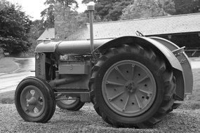 black and white photo of a tractor on a farm