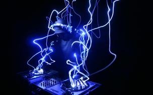 DJ at work in wires of blue light