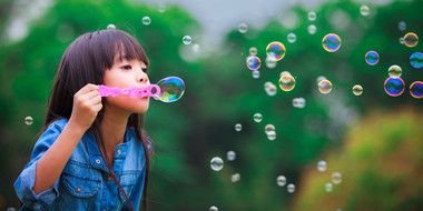 asian gir is blowing soap bubbles