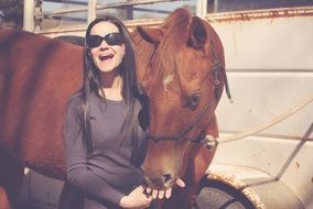 beautiful girl near a brown horse
