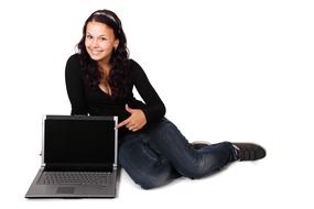 Smiling woman with laptop at white background