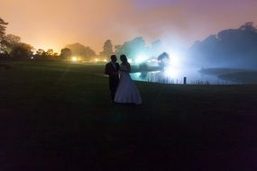 photo of newlyweds on the background of a romantic lake at dusk