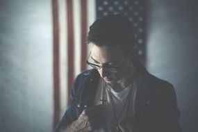 man with eyeglasses holding cross