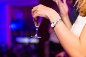 Woman hand holding glasses with drink party club night