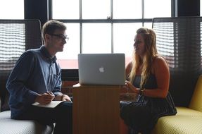 man and woman working on a laptop