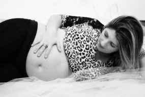 Pregnant woman lying down with his hand on his stomach