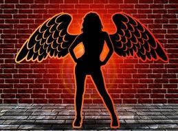 silhouette of a woman angel on a background of a brick wall