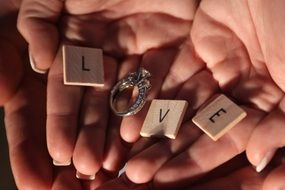 female holding love word and ring