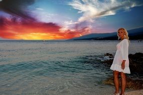 Beautiful Blonde Woman in white dress on beach sunset sea view