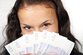 banknotes in the hands of a young happy woman