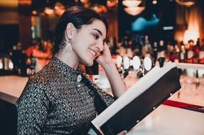 girl with long hair is studying the menu