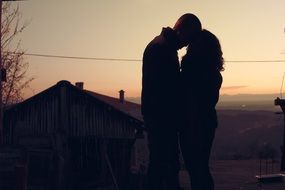 couple is kissing at the sunset