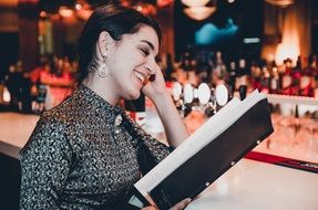 girl with long hair reads the menu