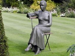 elegant woman on a chair in the park as a sculpture