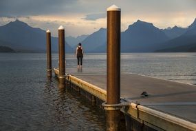 Woman standing on a pier on a lake mcdonald