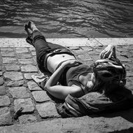 sunbathing woman at river seine bank, france, paris