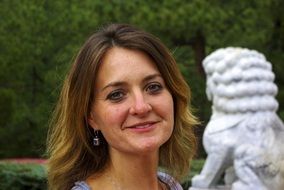 photo of a woman against a stone lion