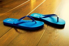 Blue bench flip flops on wooden floor