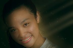 smiling young asian girl with brace on teeth