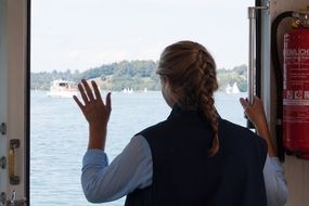 girl looks out of the window of the ferry in Tegernsee