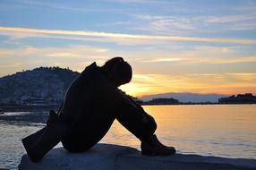 silhouette of a woman against a sea and sunset