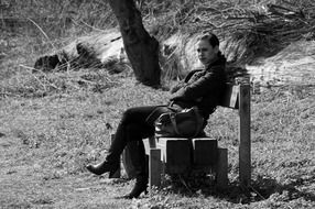 black and white photo of a girl on a bench