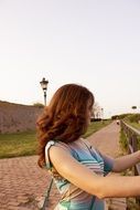 red haired beautiful young woman at fence