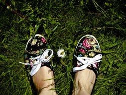 female feet in colorful shoes on green grass