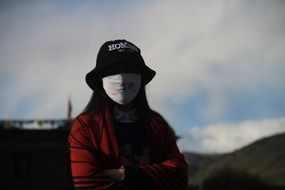 woman in mask and hat