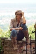 woman sitting on brick wall