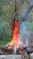 girl in a red dress on the background of the fire