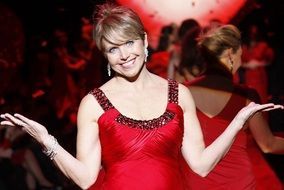 cheerful Katie Couric in red dress