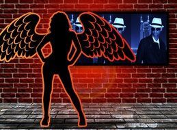 silhouette of a woman with wings on the screen background on a brick wall