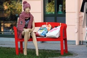 girl mannequin on a red bench