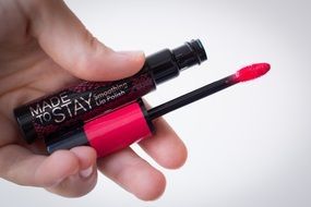 bright pink lipstick in hand close-up