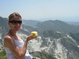 woman with apple on a background of a picturesque mountain landscape