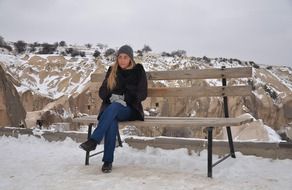 girl sitting on a bench on a mountain