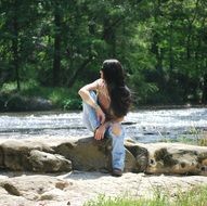 girl in jeans near the water in summer