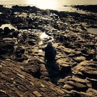 lonely girl on the coast at sunset