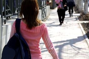 girl in a pink sweater and backpack