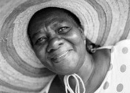 afro woman wearing hat smiling portrait
