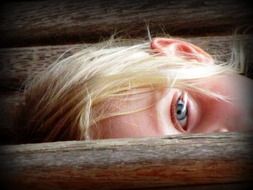 a girl with white hair peeking out from behind a fence