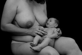 naked woman with a newborn baby in her arms