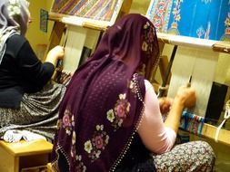 woman tying a carpet