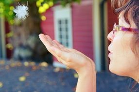 girl blowing a feather