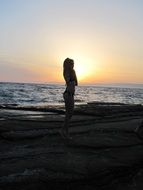 silhouette of woman on beach at sunset sky