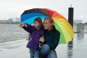 woman with child girl colorful umbrella hamburg water