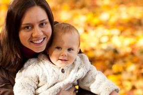 autumn photo of a happy mom with a baby