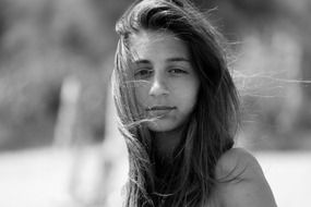 black white photo of a girl with long hair during the wind